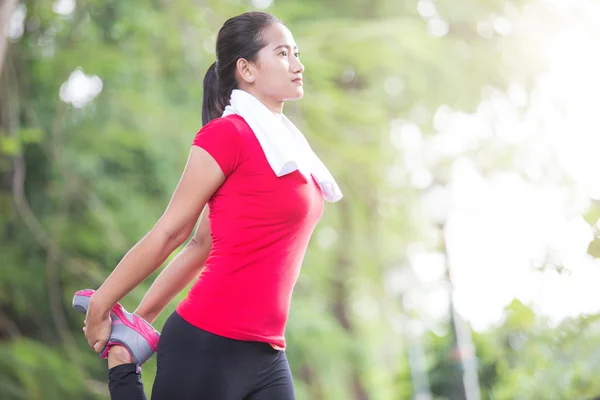 Asian woman doing stretching exercise during outdoor cross train — Stock Photo, Image