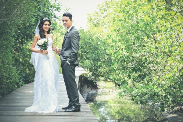 Beautiful bride and handsome groom smiling and holding each othe — Stock Photo, Image