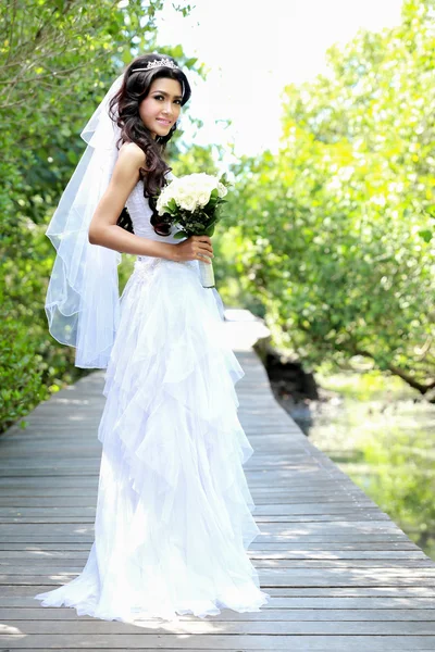 Mooie bruid glimlach terwijl een boeket — Stockfoto