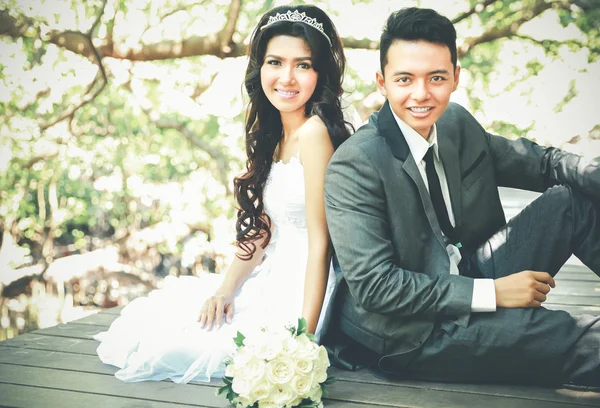 Jonge jonggehuwde paar zitten op houten pad — Stockfoto