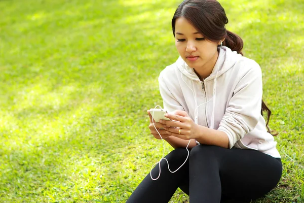 Sportieve vrouw rust na training terwijl u een muziek luistert — Stockfoto