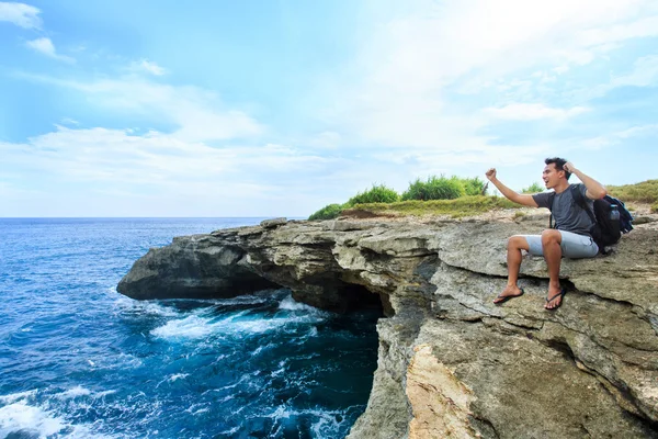 A man sitting at the edge of cliff express his feelings while lo — Stock Photo, Image