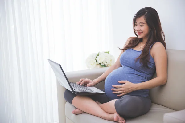 T에 앉아있는 동안 노트북 pc를 검사 하는 아름 다운 임신한 여자 — 스톡 사진
