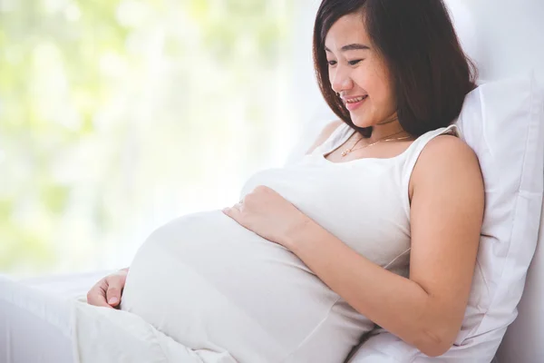 아름 다운 임신한 여자는 그녀의 배꼽을 보고 웃 고 — 스톡 사진