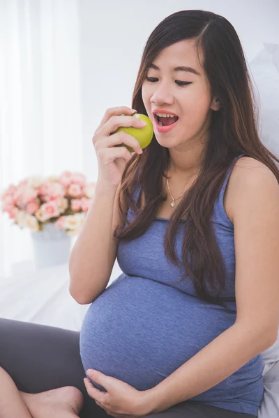 Gravid kvinna äter äpple — Stockfoto