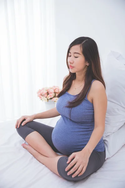 Donna incinta che prende un respiro profondo per rilassarsi mentre si siede — Foto Stock