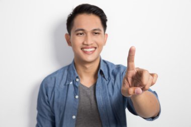 Genç Asyalı adam izole yenilmez düğmesine basarak