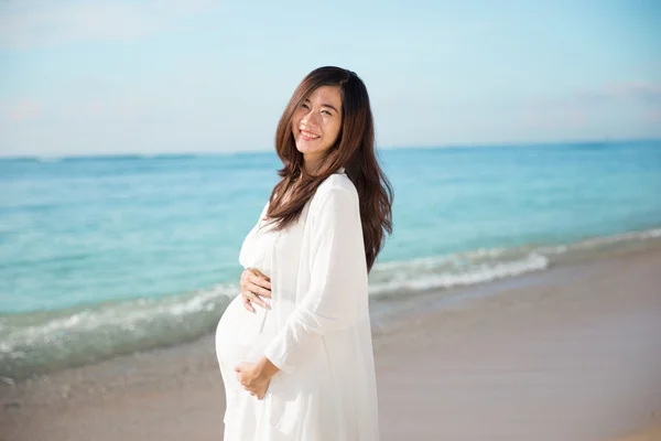 Happy asian pregnant woman smile while touching her tummy on the — Stock Photo, Image