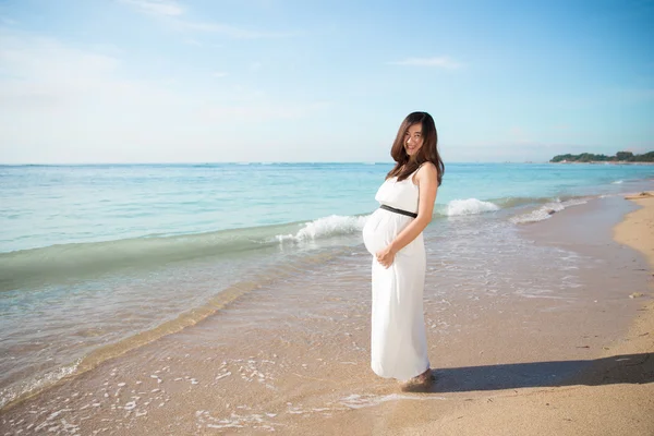 Glada gravida asiatisk kvinna ler och posera i en havsstranden — Stockfoto