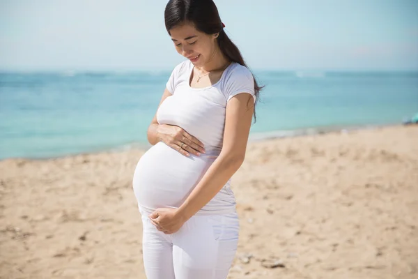 Asian pregnant woman smile while touching her belly — Stock Photo, Image