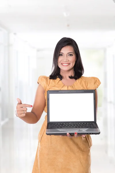 Mujer asiática sosteniendo un portátil abierto, apuntando a la computadora portátil — Foto de Stock
