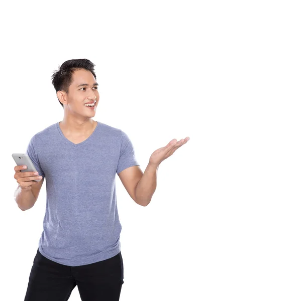 Азиатский молодой человек держит в руках телефон, показывая жест рукой — стоковое фото