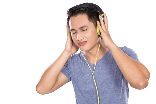 Joven asiático hombre escuchando música con un auricular — Foto de Stock