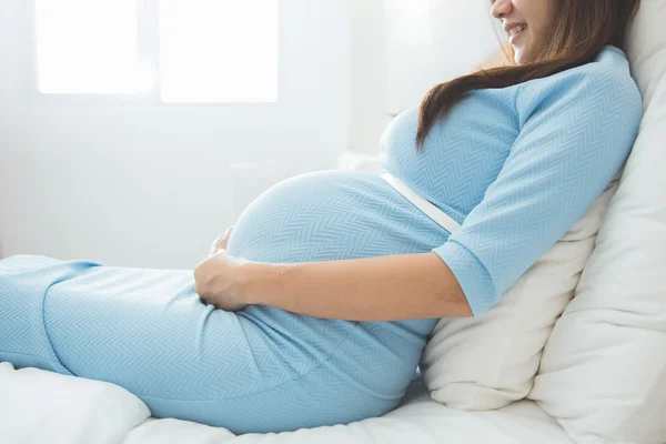 Asiática embarazada feliz mujer sentado en la cama, sonrisa — Foto de Stock