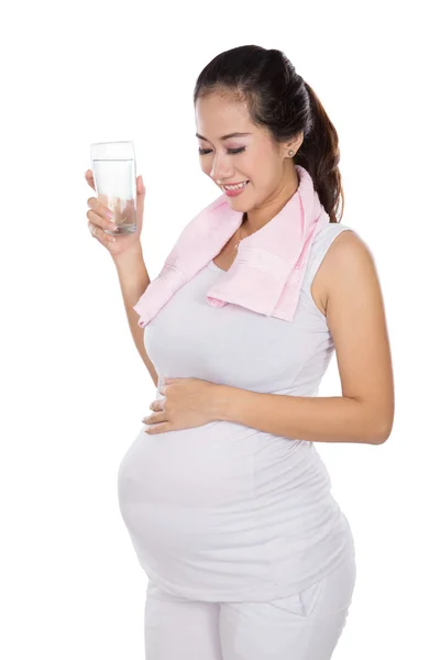 Hermosa embarazada asiático la celebración de un vaso de agua sonriendo — Foto de Stock