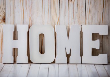 Ahşap arka plan üzerinde beyaz ev işareti