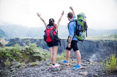 Mixed couple go trekking together, nature background, winning ha