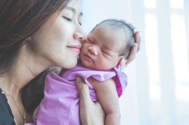 Genç anne onun yeni doğan esneme bebek tutan gülümseme mutlu