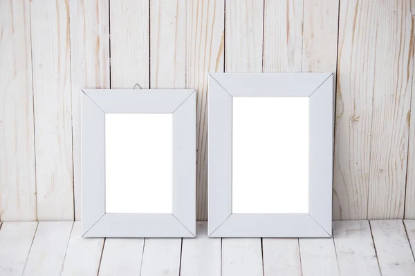 Two kind sizes of white frame on wooden background — Stock Photo, Image