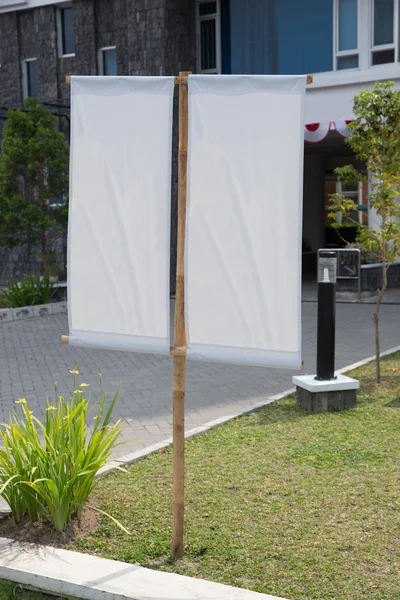 Blank white banner on a grass yard in front of an office, mock u — Stock Photo, Image