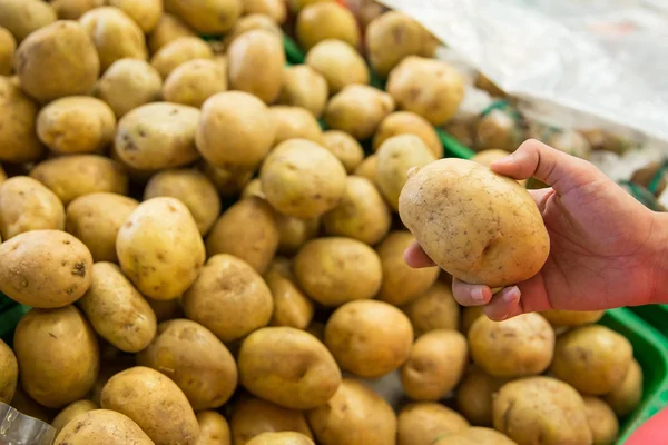 Női kézi szedés a burgonya, a piacon — Stock Fotó