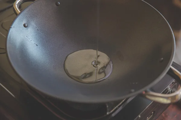 Chef pouring oil in to the frying pan for cooking — Stock Photo, Image