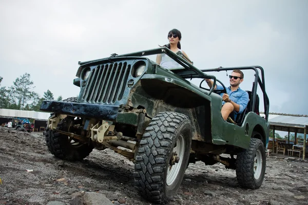 Mixed race couple riding a jeep off road — Stock Photo, Image