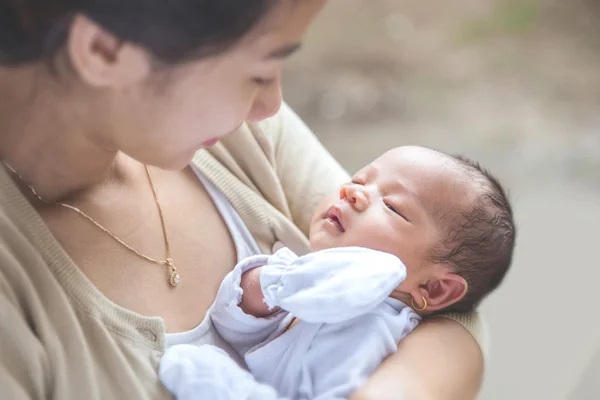 Милый новорожденный, носимый матерью — стоковое фото
