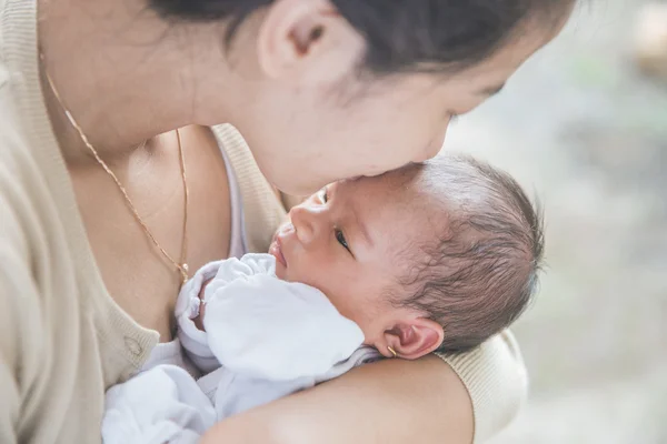 Милый новорожденный, носимый матерью — стоковое фото