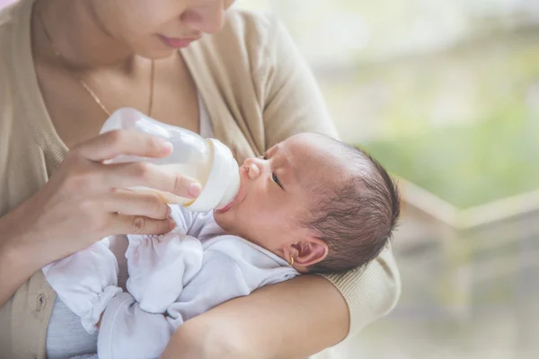 Bebê recém-nascido bonito sendo alimentado por sua mãe usando garrafa — Fotografia de Stock