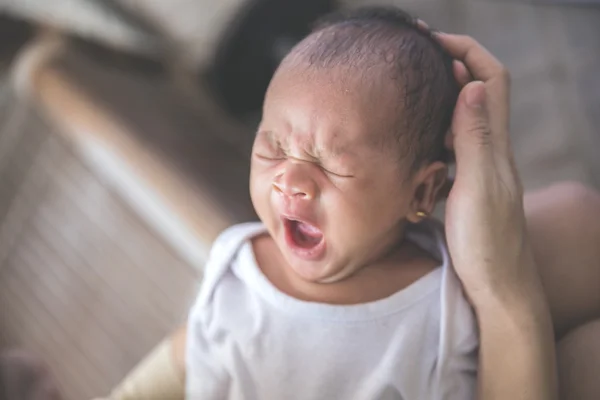 Carino neonato portato da sua madre mentre sbadigliava — Foto Stock