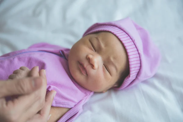 Новорожденный держит палец — стоковое фото