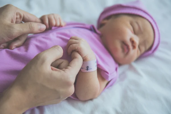 Новорожденный держит палец — стоковое фото