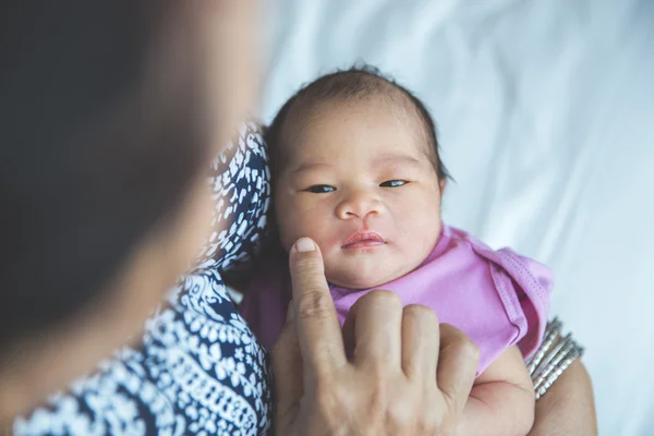 Милый новорожденный ребенок, носимый ее матерью во время зевоты — стоковое фото