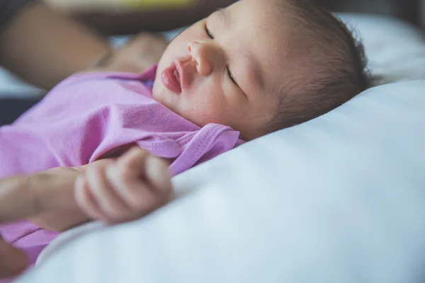 Neonato rannicchiato che dorme su una coperta, tenendo il dito, cl — Foto Stock