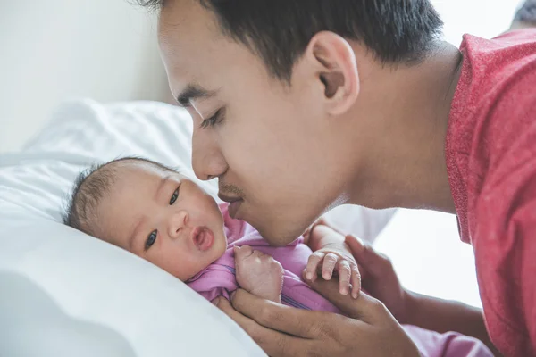 Young Asian father kissing his newborn baby, close up — Stock Photo, Image