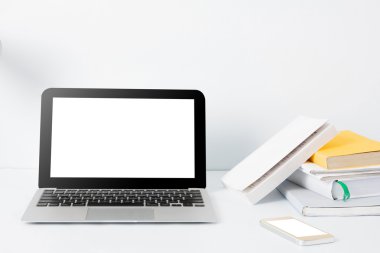 dizüstü bilgisayar, akıllı telefon ve Ofis Masası adlı kitap yığını