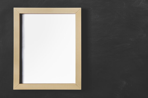 Portrait of empty wooden photo frame on black board for background with copy space