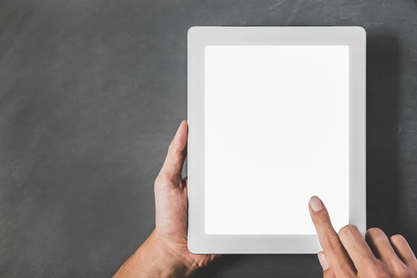 Mani che tengono e toccano lo schermo del tablet con bianco vuoto — Foto Stock