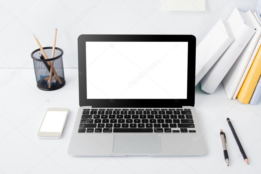 working desk with laptop, books and stationery