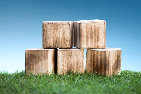 Blocos de madeira em uma grama verde — Fotografia de Stock