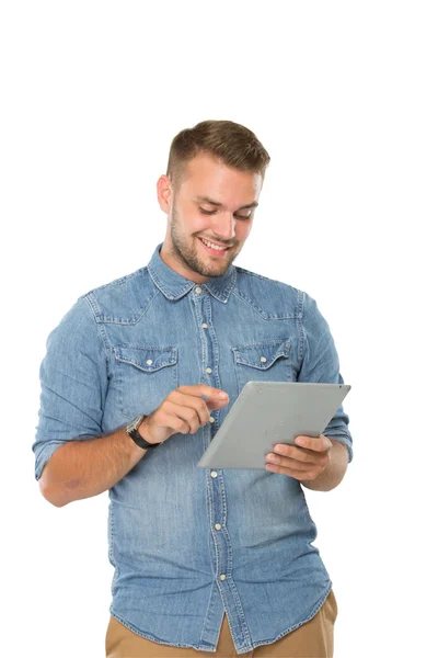 Młody człowiek ogląda z komputera typu Tablet, uśmiechając się — Zdjęcie stockowe