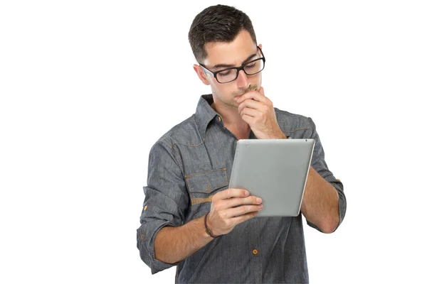 Junger Mann schaut lächelnd auf einen Tablet-PC — Stockfoto