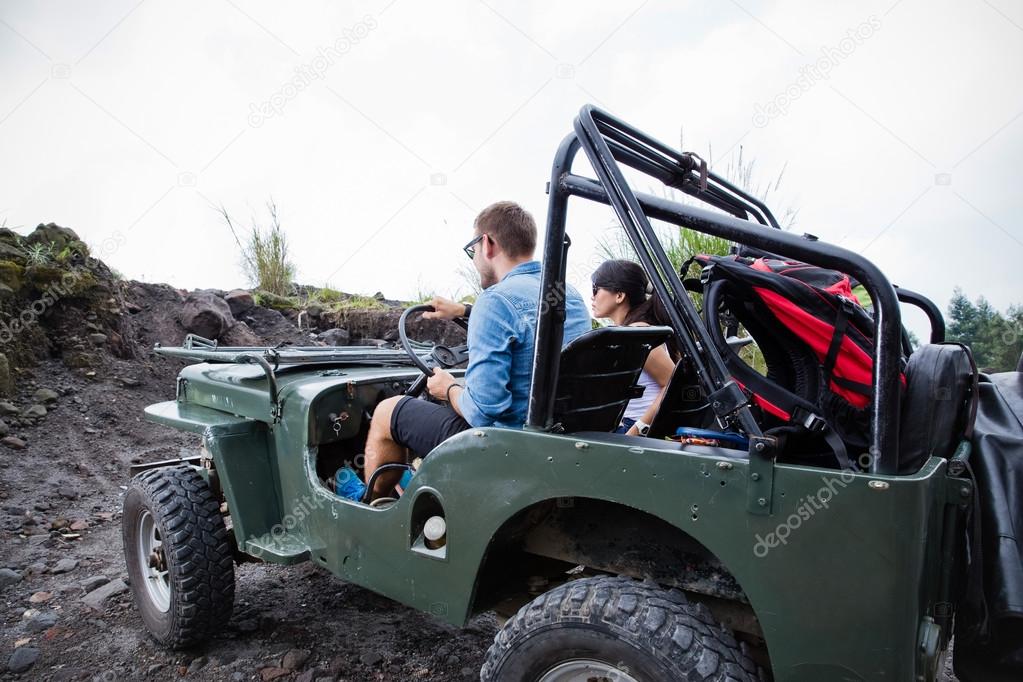 Mixed couple riding a jeep off road