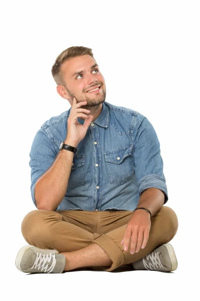 Young man sitting on the floor, imagining — Stock Photo, Image