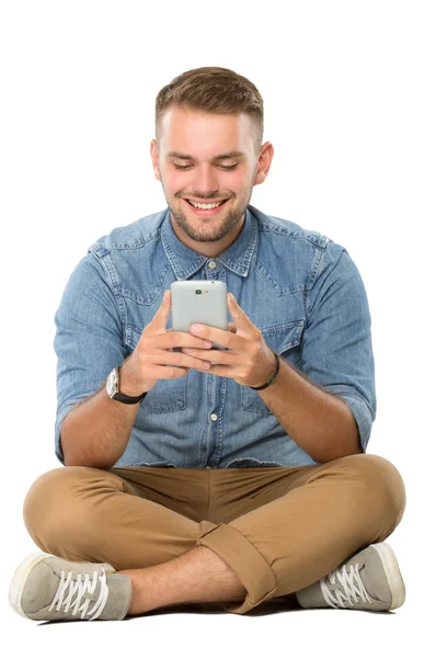 Junger Mann liest etwas auf seinem Handy — Stockfoto