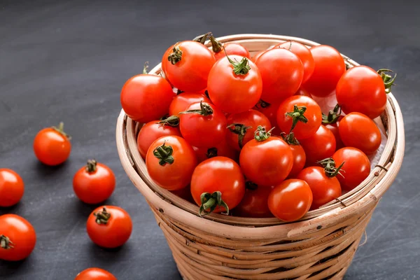 Pila de tomates cherry en una cesta de ratán —  Fotos de Stock