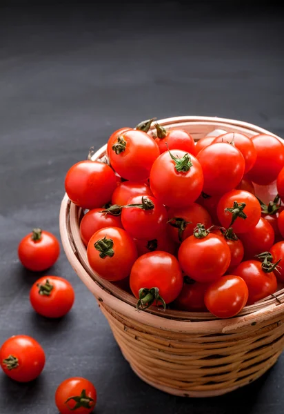 Pilha de tomates cereja em uma cesta de vime — Fotografia de Stock