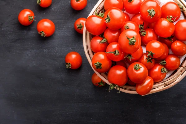 Pilha de tomates cereja em uma cesta de vime — Fotografia de Stock