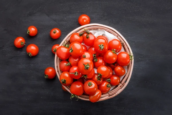 Kupie Pomidory czereśniowe w koszyk rattan — Zdjęcie stockowe